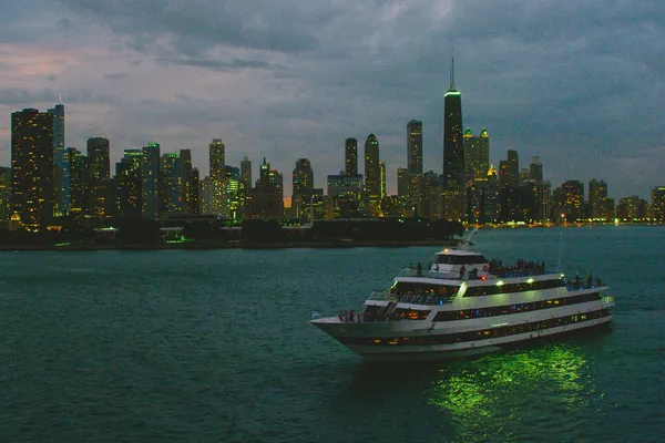 A boat on the Chicago River with the city skyline in the background.